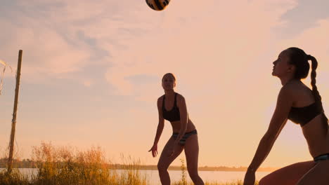Chicas-Sexy-De-Voleibol-En-Bikini-Juegan-En-La-Playa-En-Verano-Voleibol-En-La-Arena-Al-Atardecer-En-Cámara-Lenta
